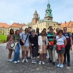 “在记忆的边缘”研讨会的参与者在波兰华沙的皇家城堡外. 全球体验办公室助理主任兼留学顾问Kathy L和on, 左第一排, 他和埃里克·博因顿总统一起领导了这个组织.